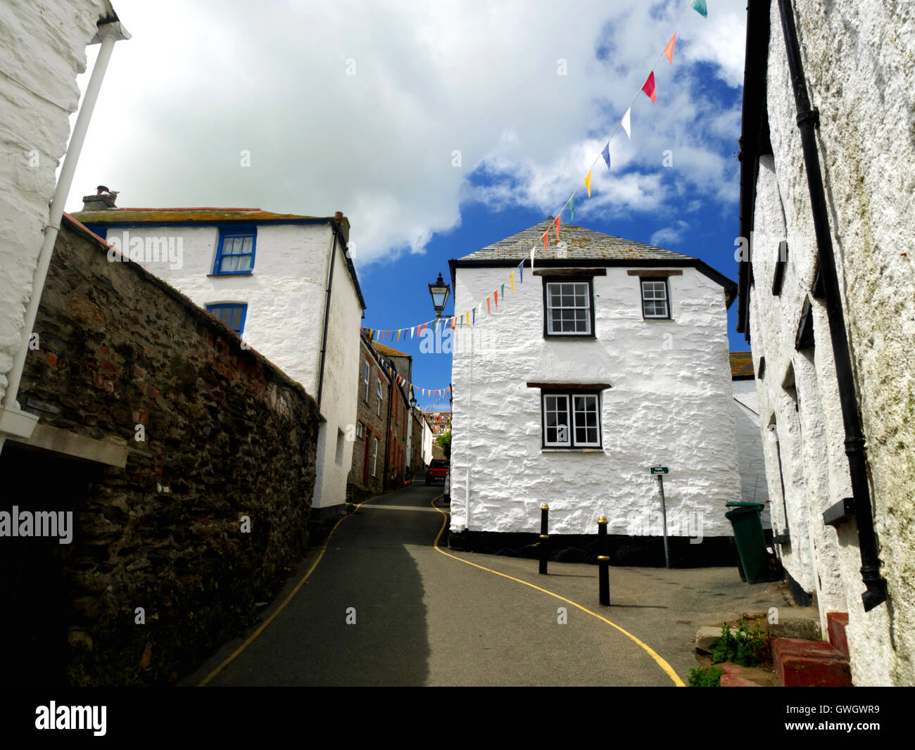 White-washed cottages line steep Church Street in the Cornish fishing village of Gorran Haven. Stock Photo