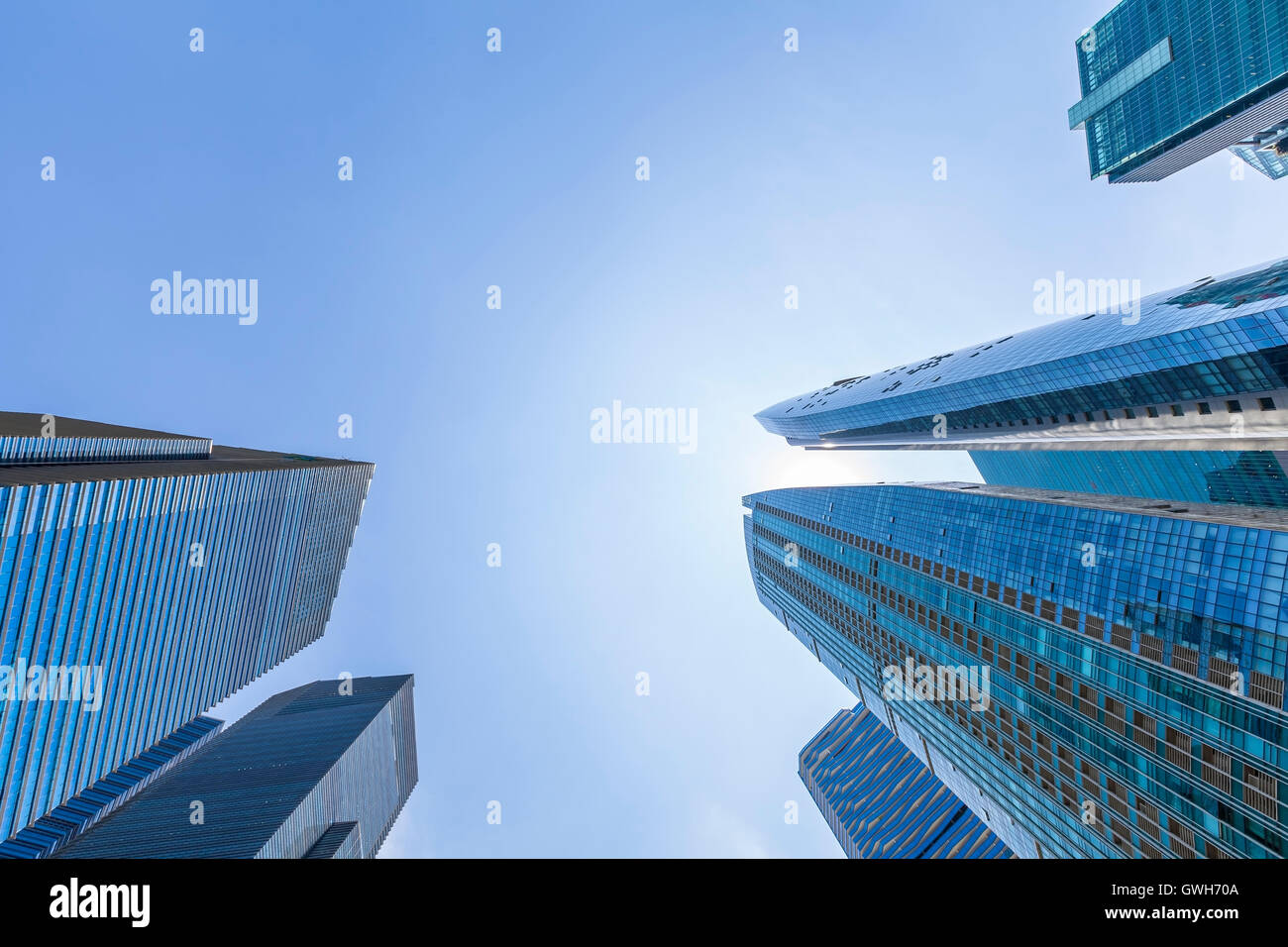 Abstract up view of skyscrapers with blue sky in Singapore downtown. Business and finance headquarters. Sun reflecting Stock Photo