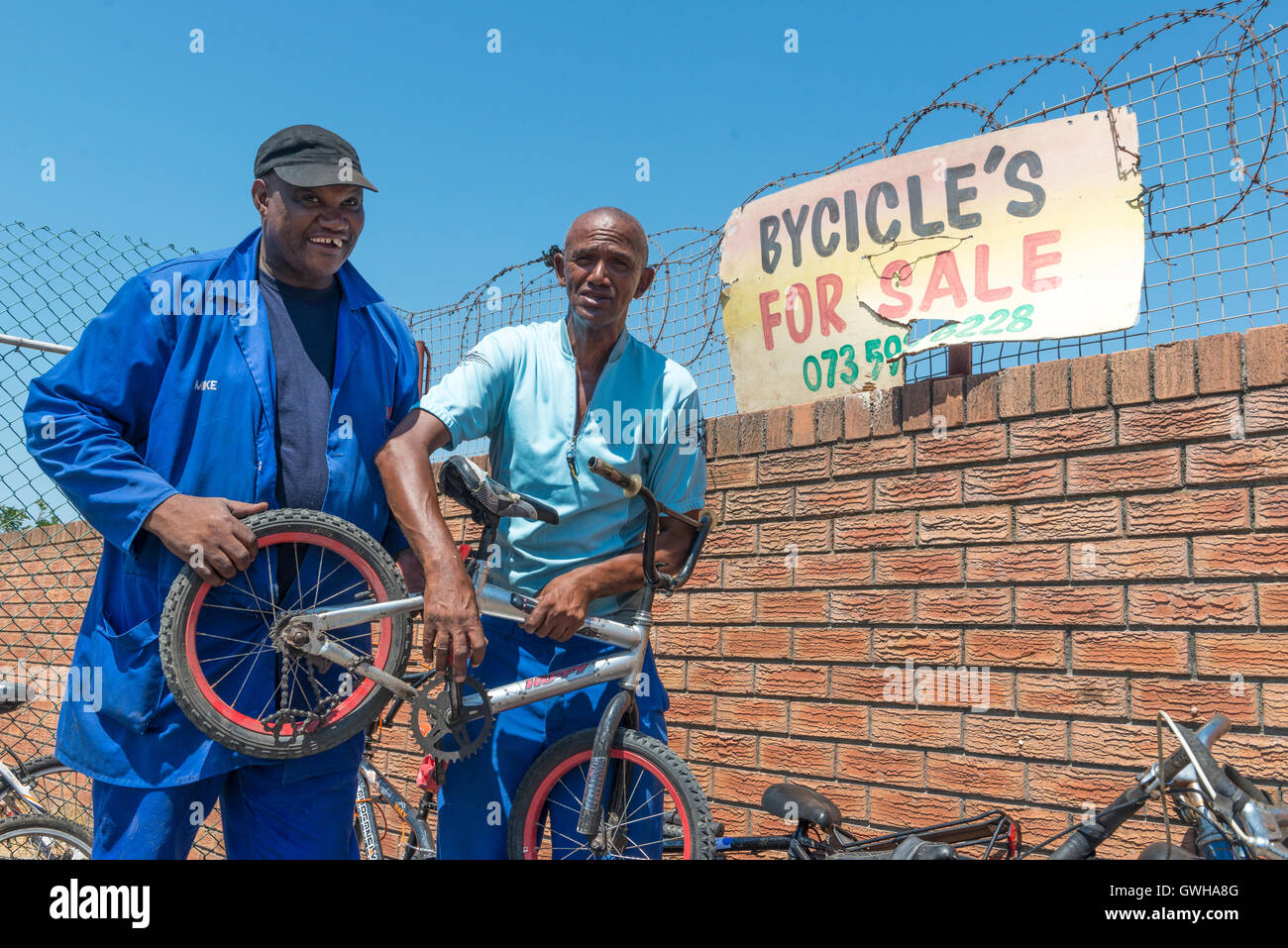 Bicycle mechanic selling a child's bike to a customer, Cape Town, South