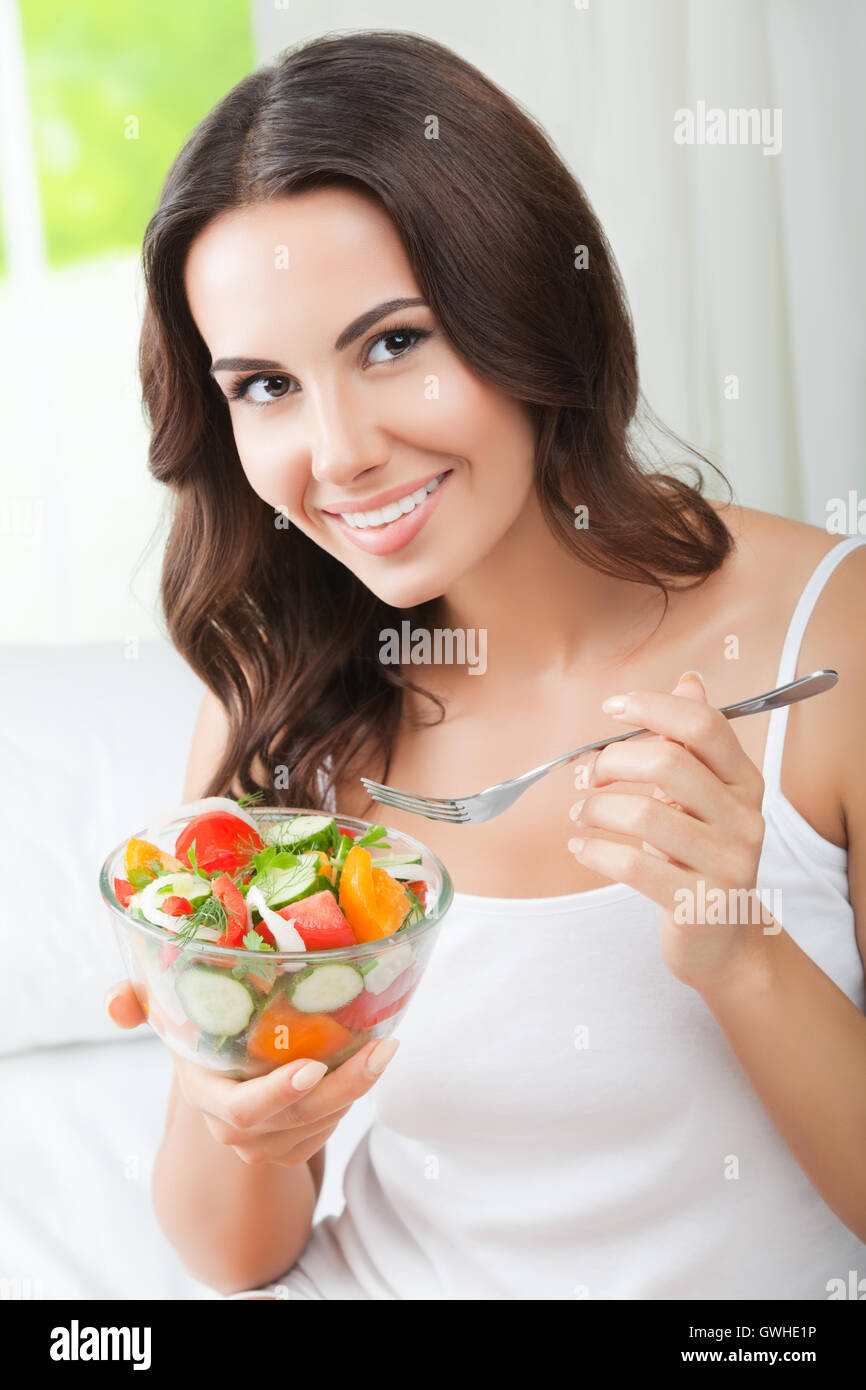Portrait of happy smiling young brunette woman with vegetarian ...