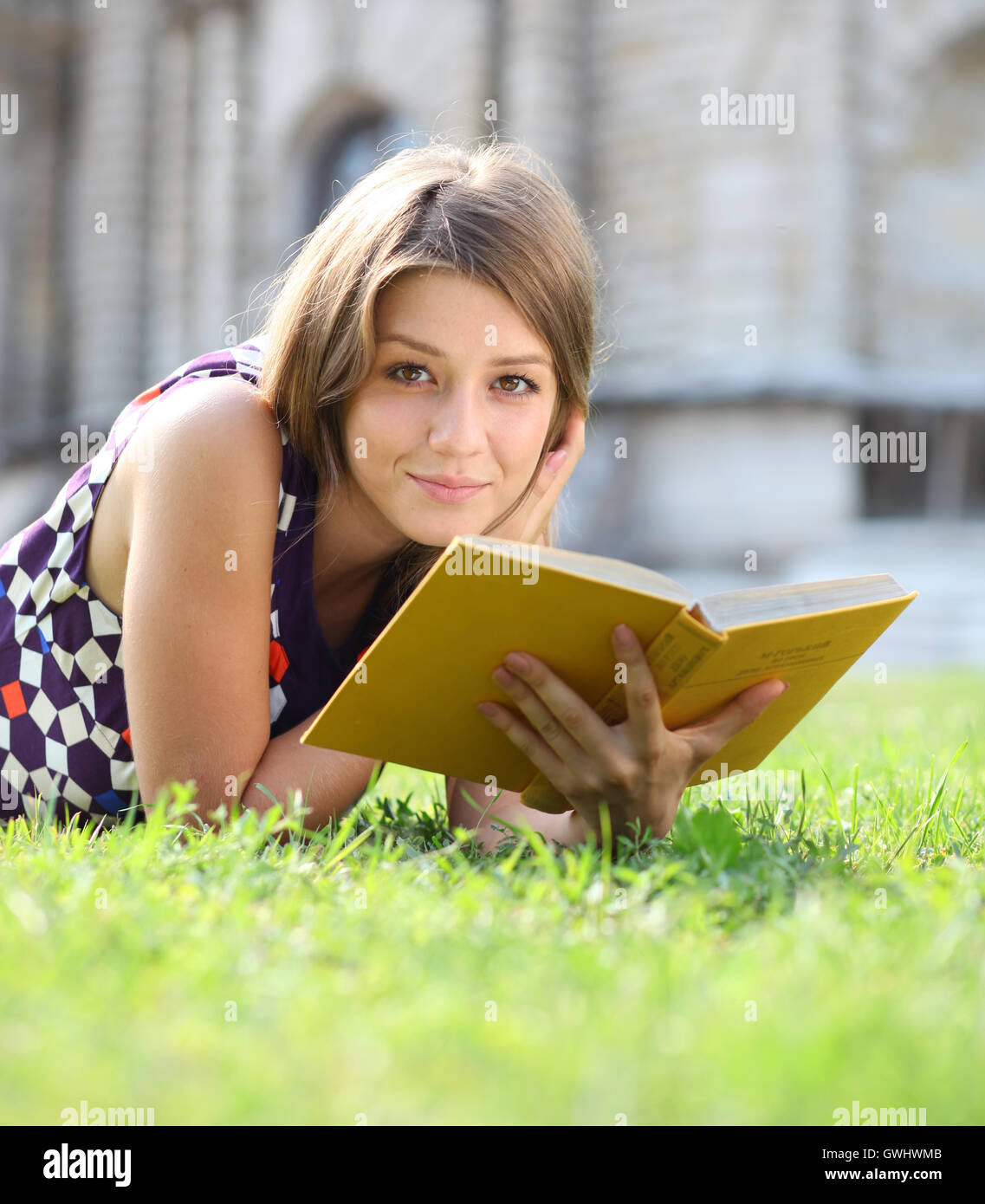 Young beautiful girl reading a book outdoor Stock Photo - Alamy