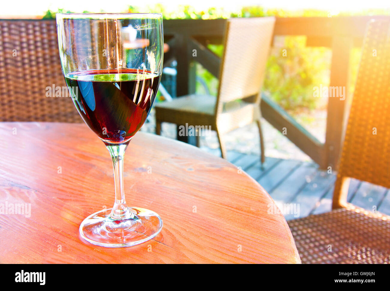 Glass of red wine on the table in restaurant at summer. Stock Photo