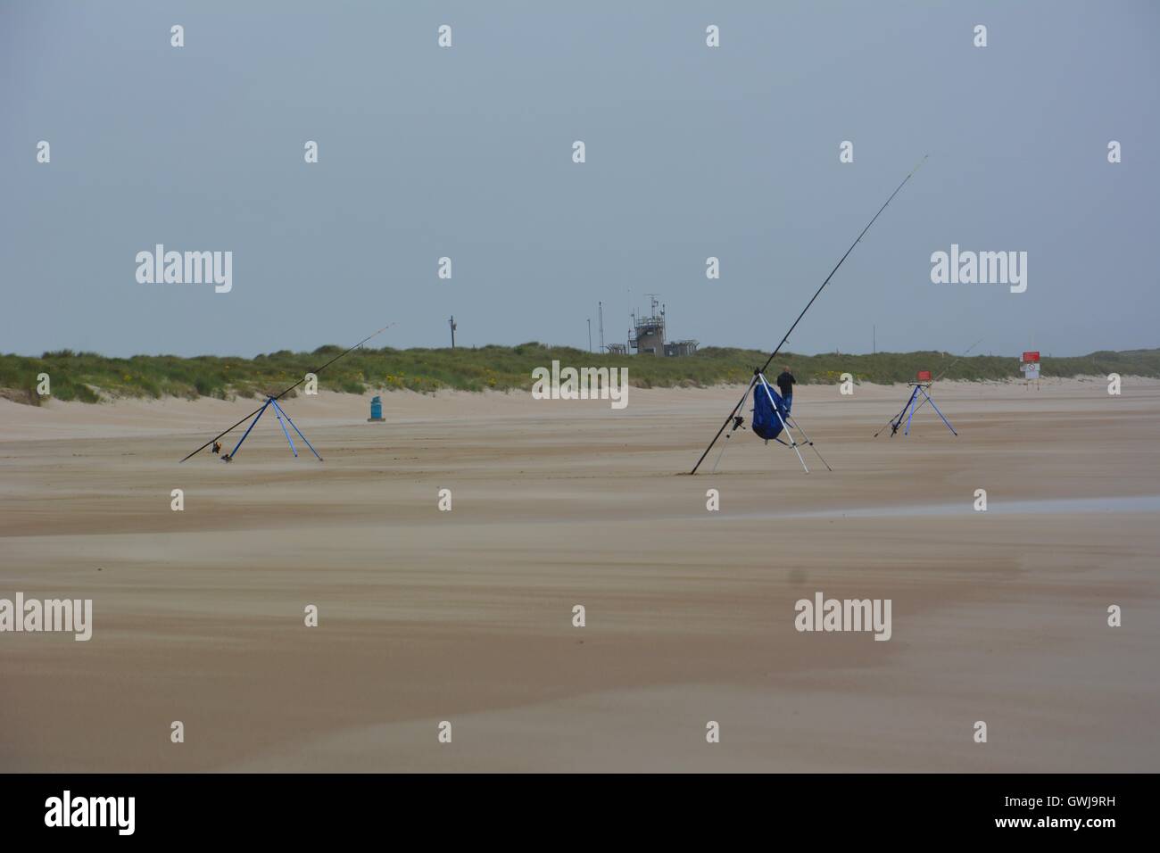 Lonely anglers on a stormy beach Stock Photo