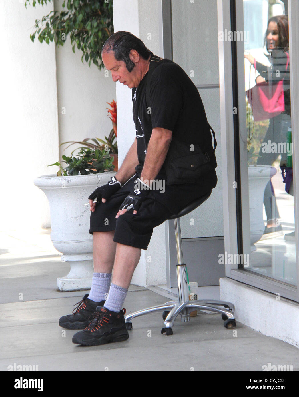 Andrew Dice Clay sits down to have a cigarette whilst out in Beverly