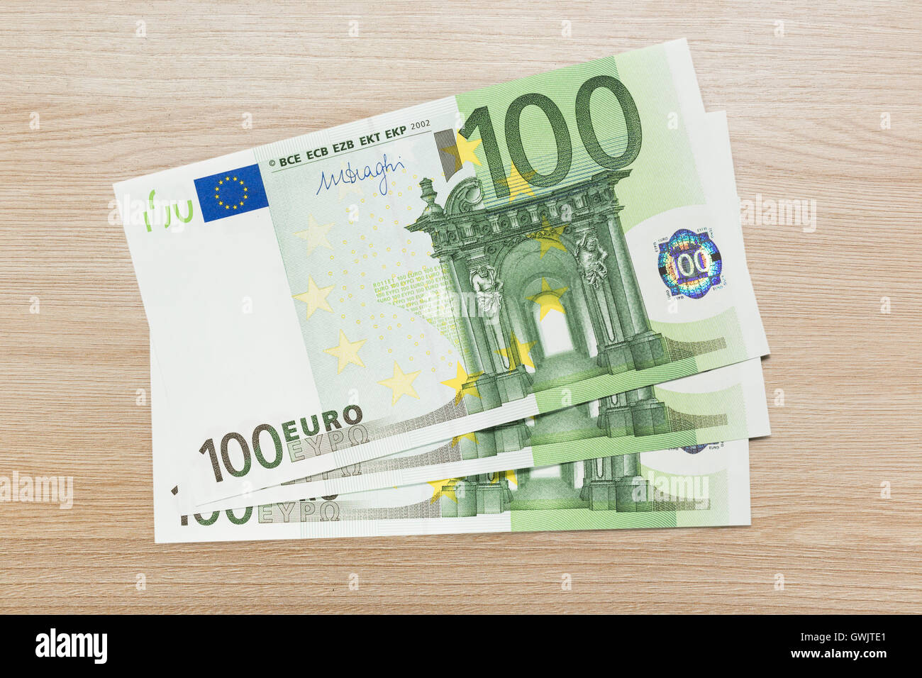 One hundred euro banknotes on wooden background Stock Photo