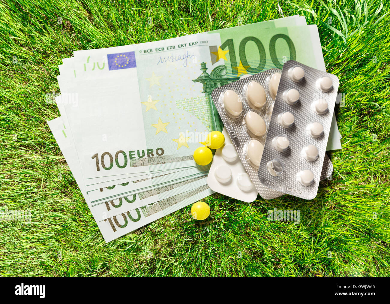 One hundred euro banknotes and pills closeup Stock Photo - Alamy