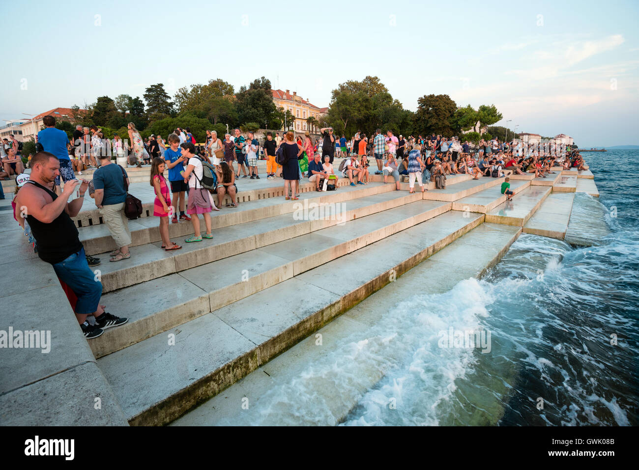 ZADAR, CROATIA - SEPTEMBER 1, 2016: People visit famous sea organ and watch sunset in Zadar, Croatia. Stock Photo