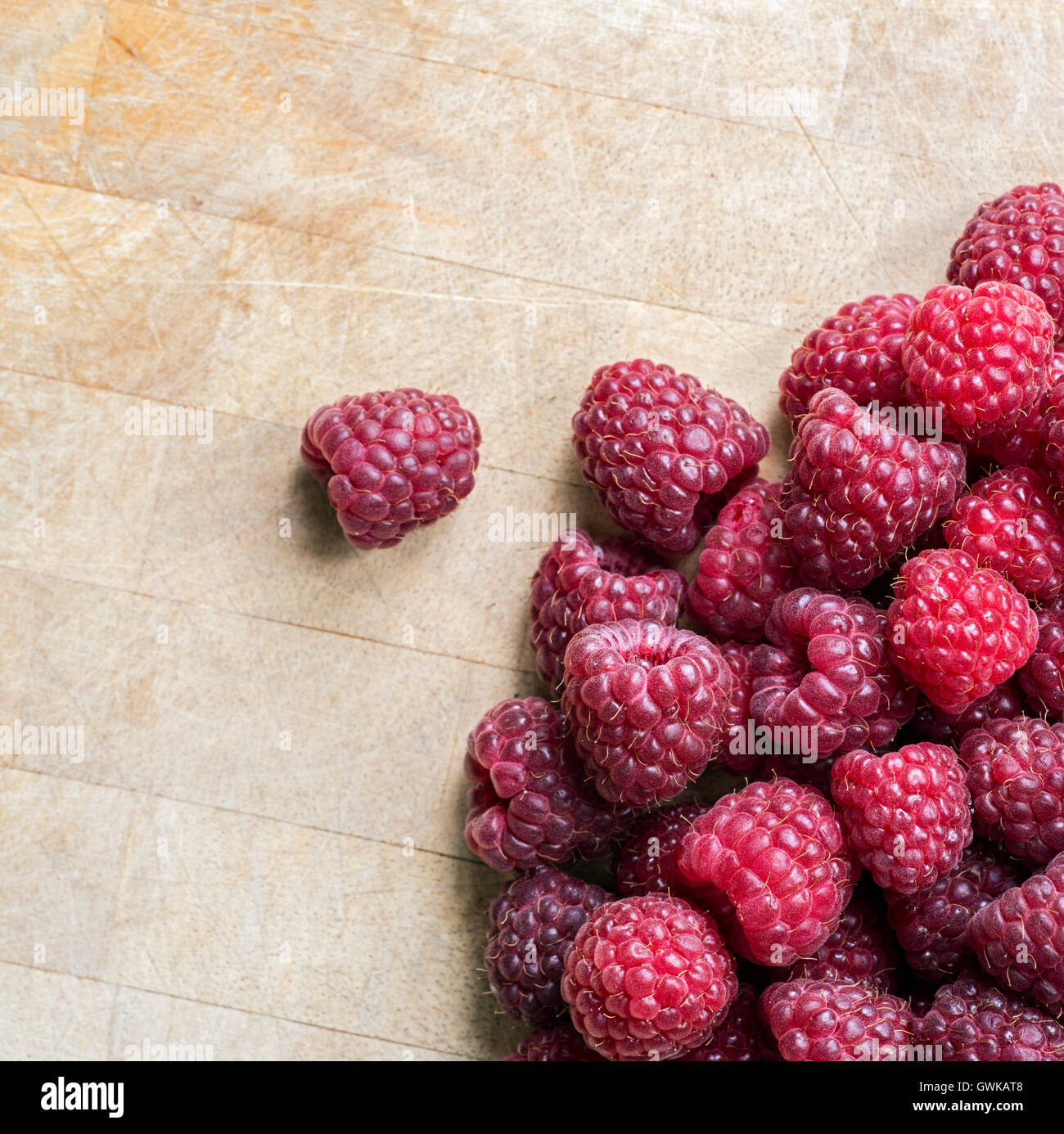 A pile of fresh raspberries on a wooden board Stock Photo