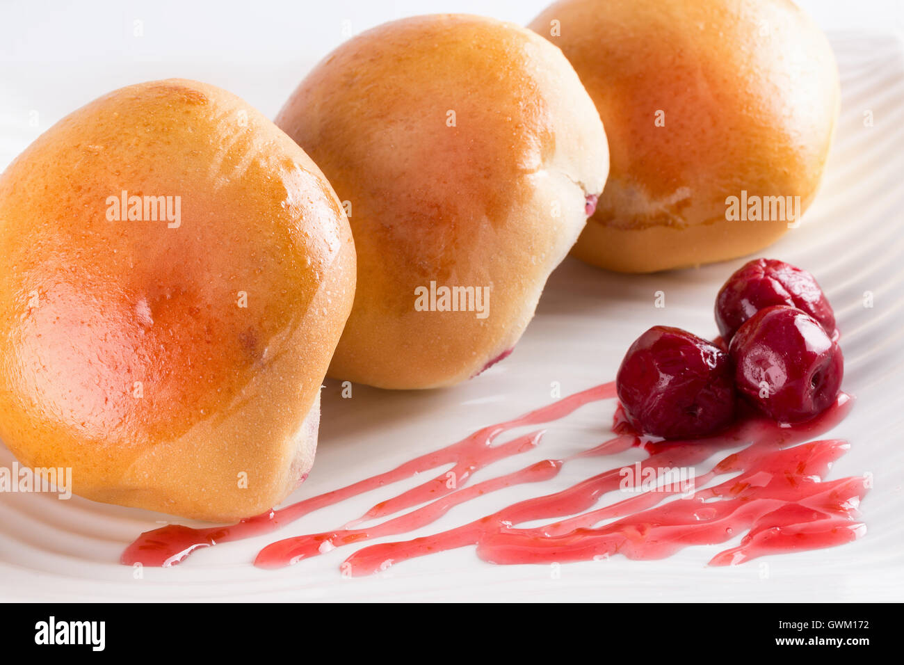 patties with cherries on white plate. Stock Photo
