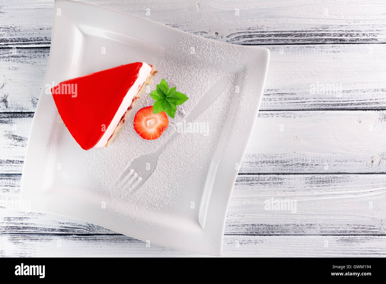 piece of jelly cake with strawberry on white wooden background Stock ...