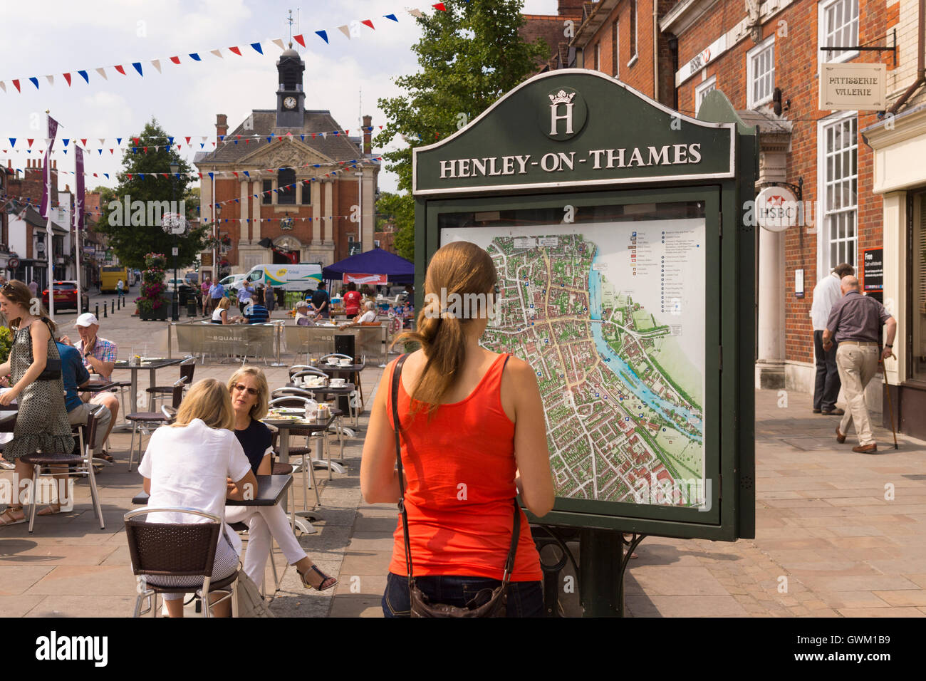 A tourist examines a map board in HenleyonThames for directions Stock