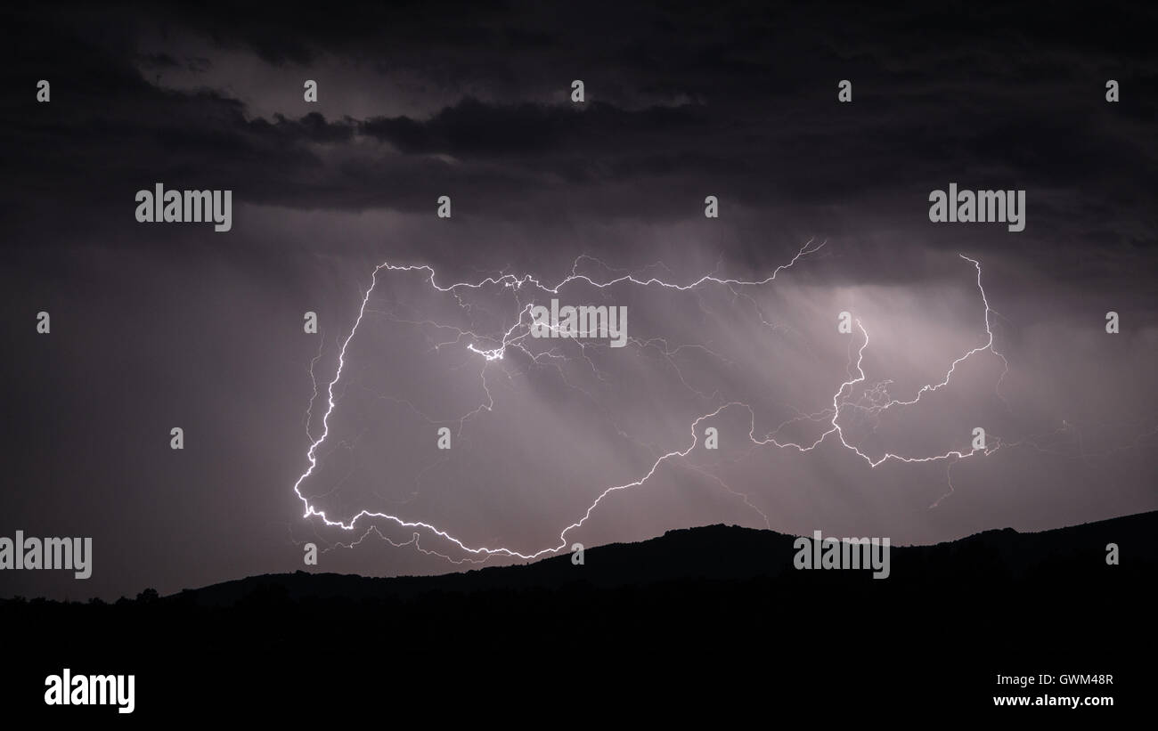 Lightning strike over mountain range Stock Photo