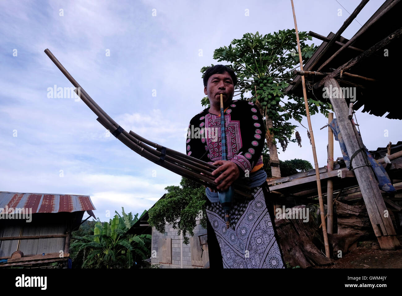 A member of Hmong Tribe playing a traditional Kleng pipe organ in Mae Khi village in Mae Rim District, Chiang Mai, northern Thailand. Many Hmong people migrated from Laos to Thailand following the victory of the Pathet Lao in the late 1970s. While some ended up in refugee camps, others settled in mountainous areas becoming one of the ethnic groups referred to as Hill Tribes in Thailand Stock Photo