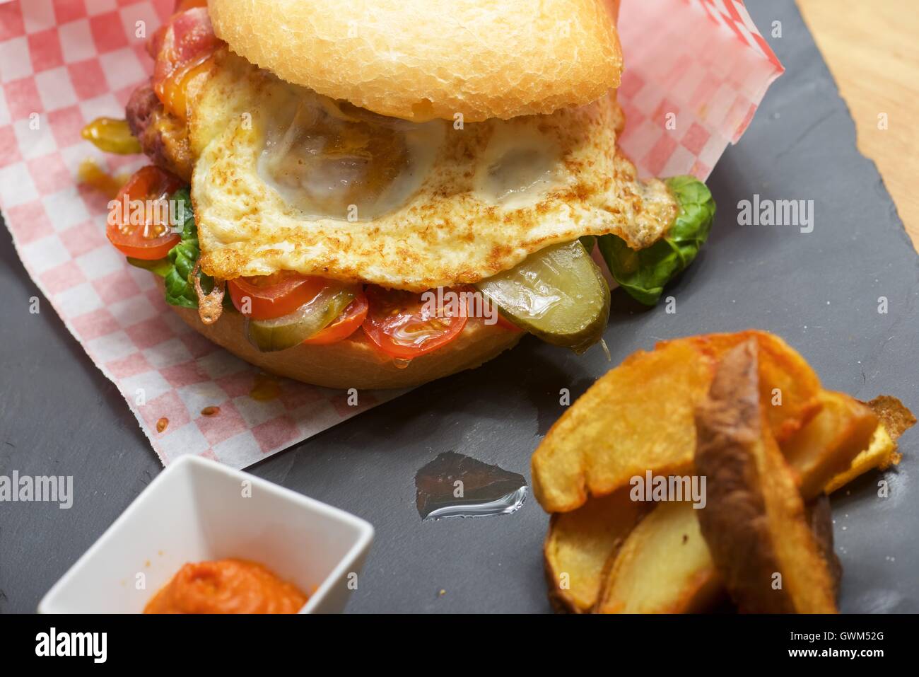 Beef burger with fried egg and chips Stock Photo Alamy