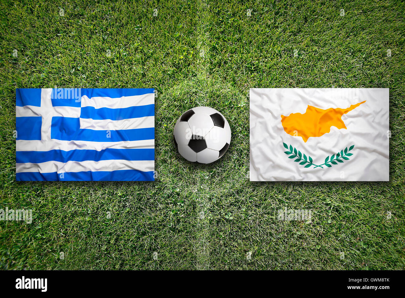Greece and Cyprus flags on a green soccer field Stock Photo