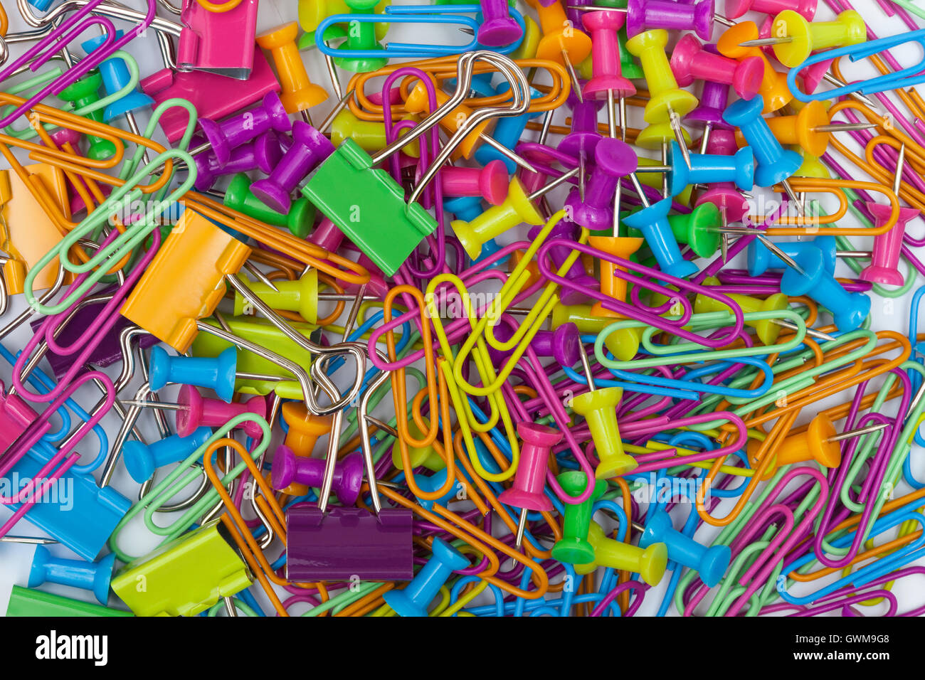 Office supplies - thumb tacks, paper cliups and paper clamps, full frame Stock Photo