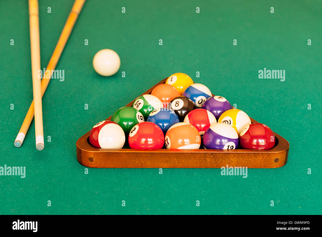 Pool cue sticks, a cue ball and a rack of balls ready for a game of eight- ball pool Stock Photo - Alamy