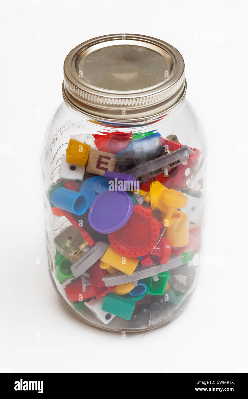 An old jar filled with a variety of old game pieces Stock Photo