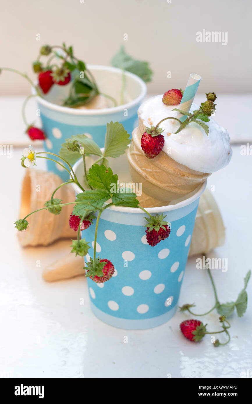 ice cream with forest wild strawberries in a cup blue with white polka dots Stock Photo