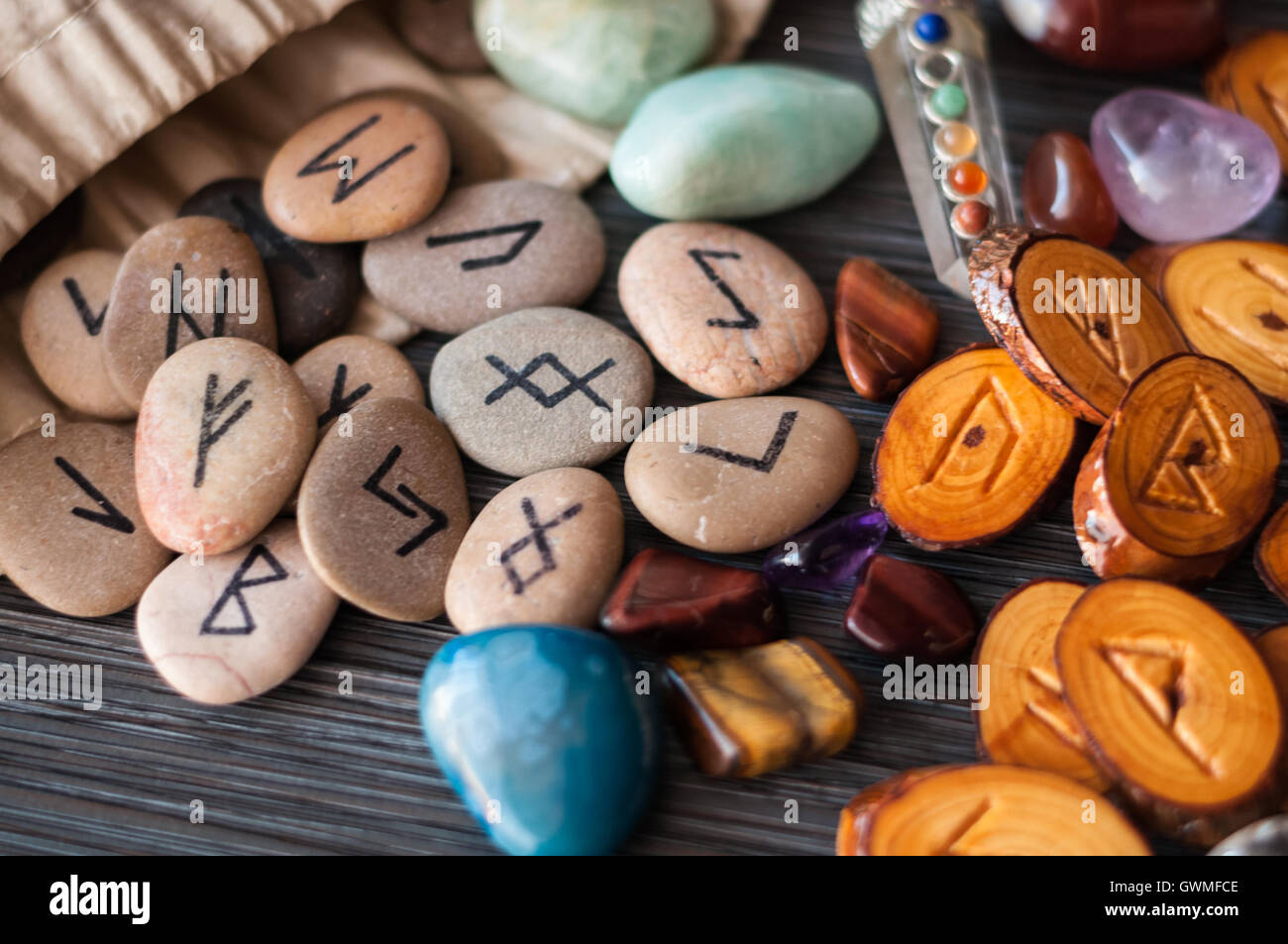 wooden, rune stone with his own hands among the crystals on a dark background Stock Photo