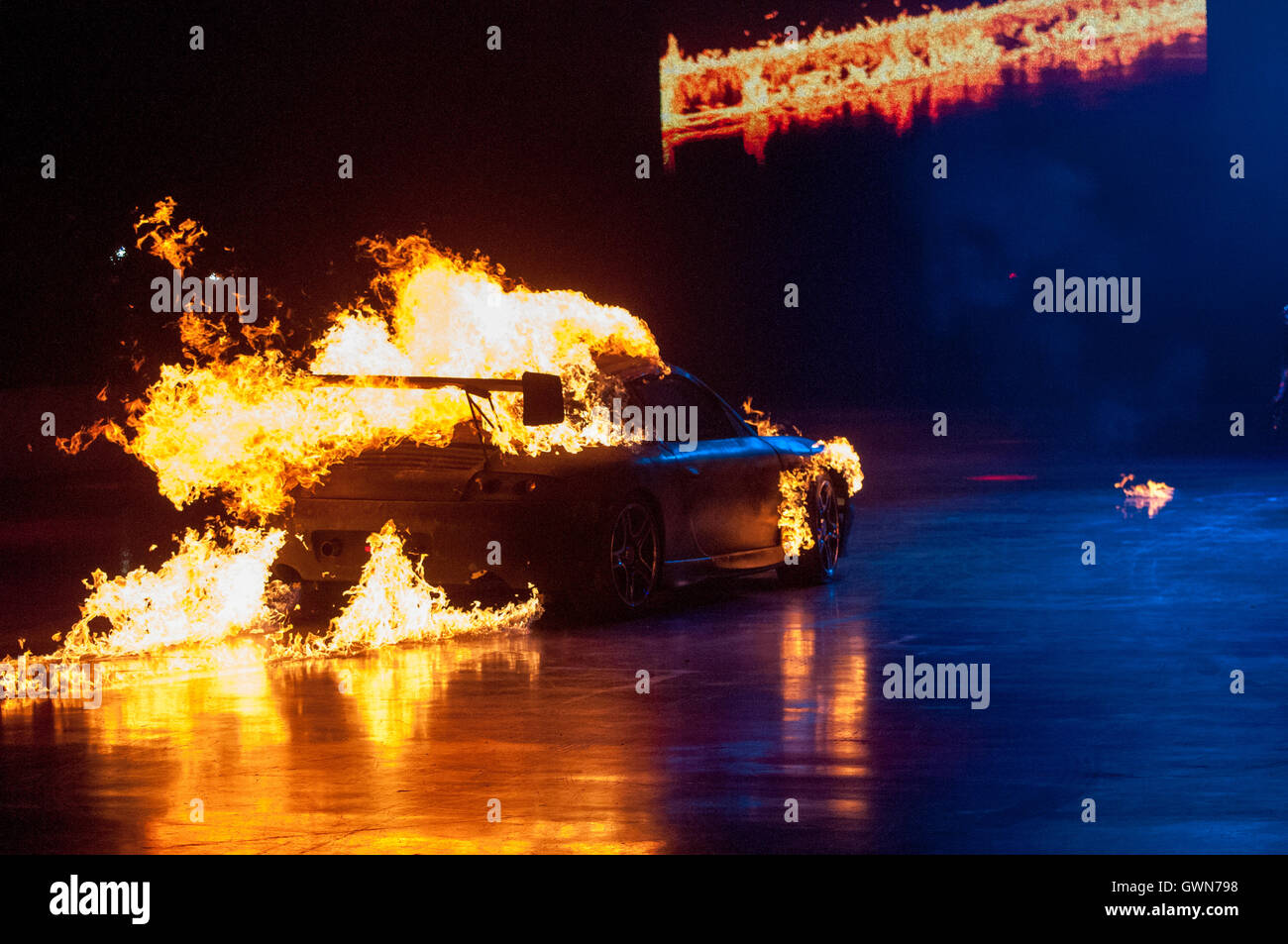 A black car in flames during Clarkson, Hammond and May Live, which toured just after the three presenters left BBC Top Gear Stock Photo