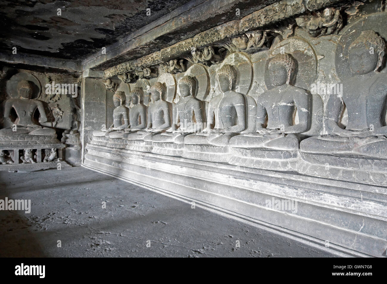 Seven images of Buddha in meditation carved out of rock inside a Buddhist rock cave (Teen Daal). Cave number 12, Ellora Caves. Stock Photo