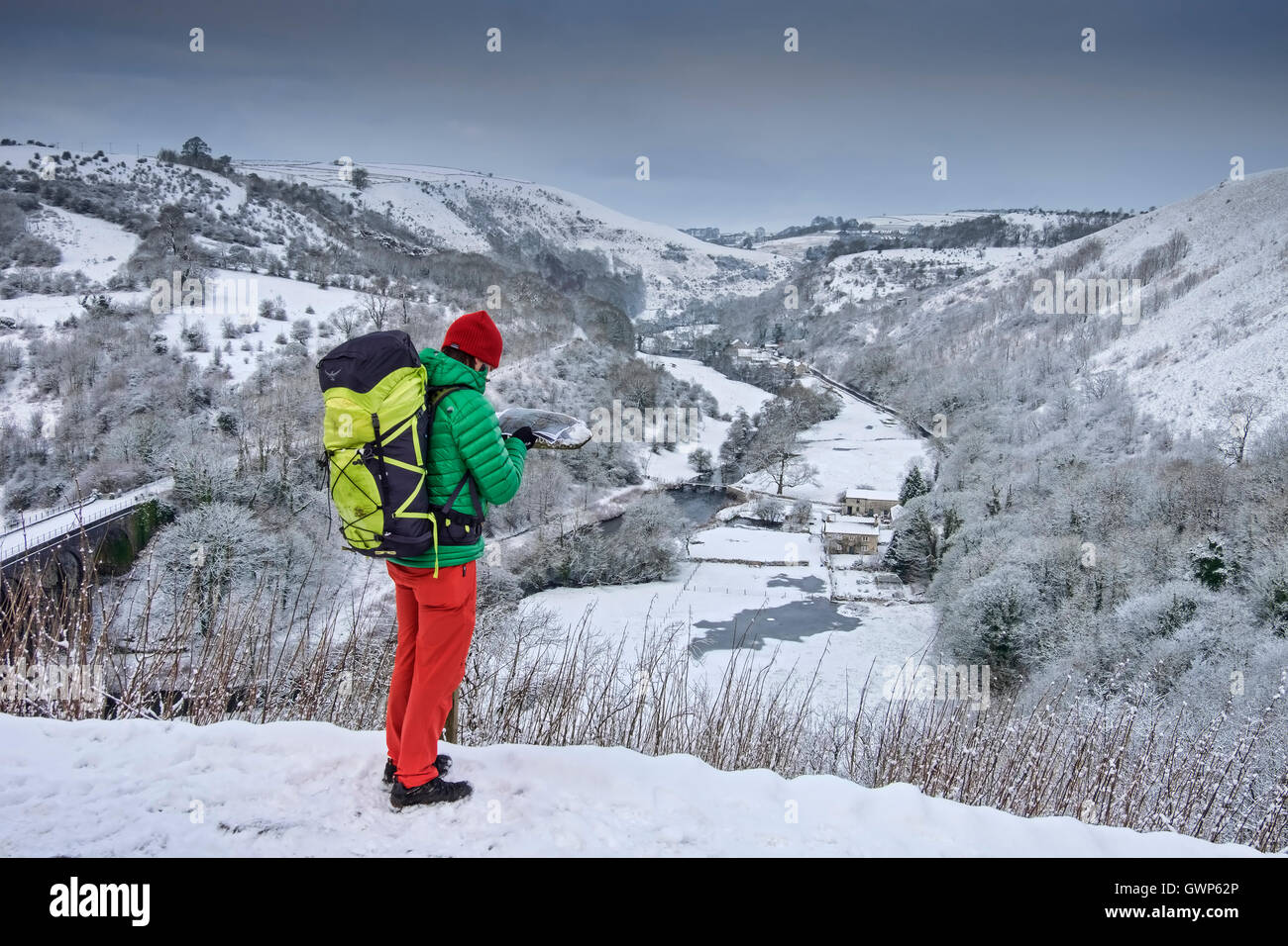 Walker in colourful clothes at Monsal Head overlooking Monsal Dale in winter, Peak District National Park, Derbyshire, England Stock Photo