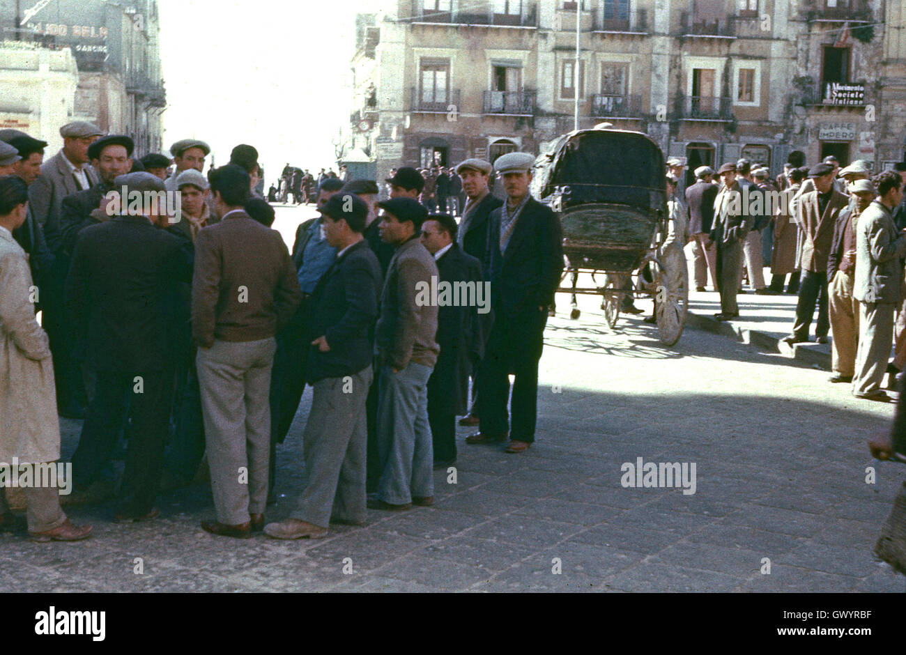 1951 historical, post-world war 11 and unemployed men gather in the town square of Gela, Sicily, Italy. Stock Photo
