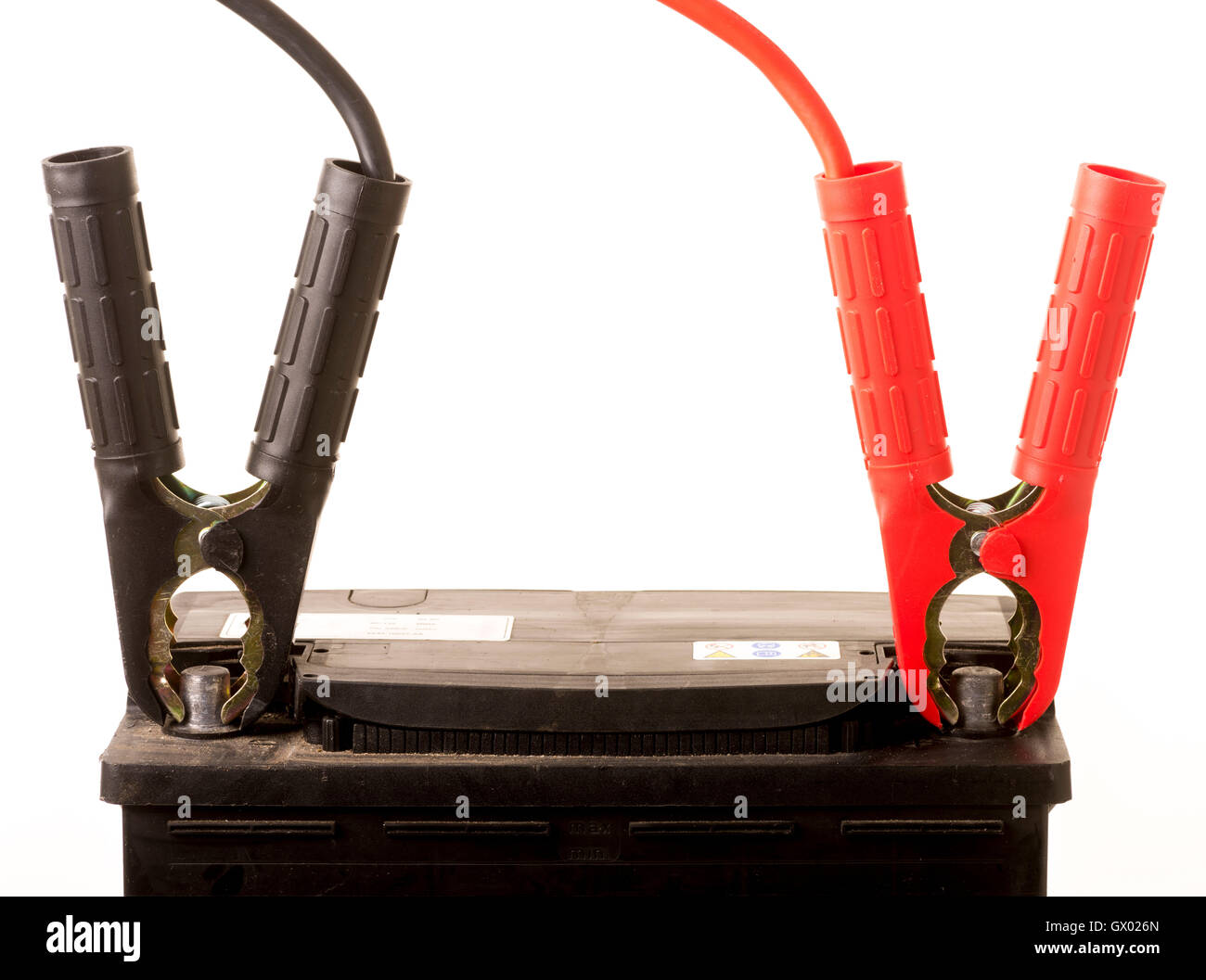 Car positive and negative, red and black, jump leads on car battery. Stock Photo