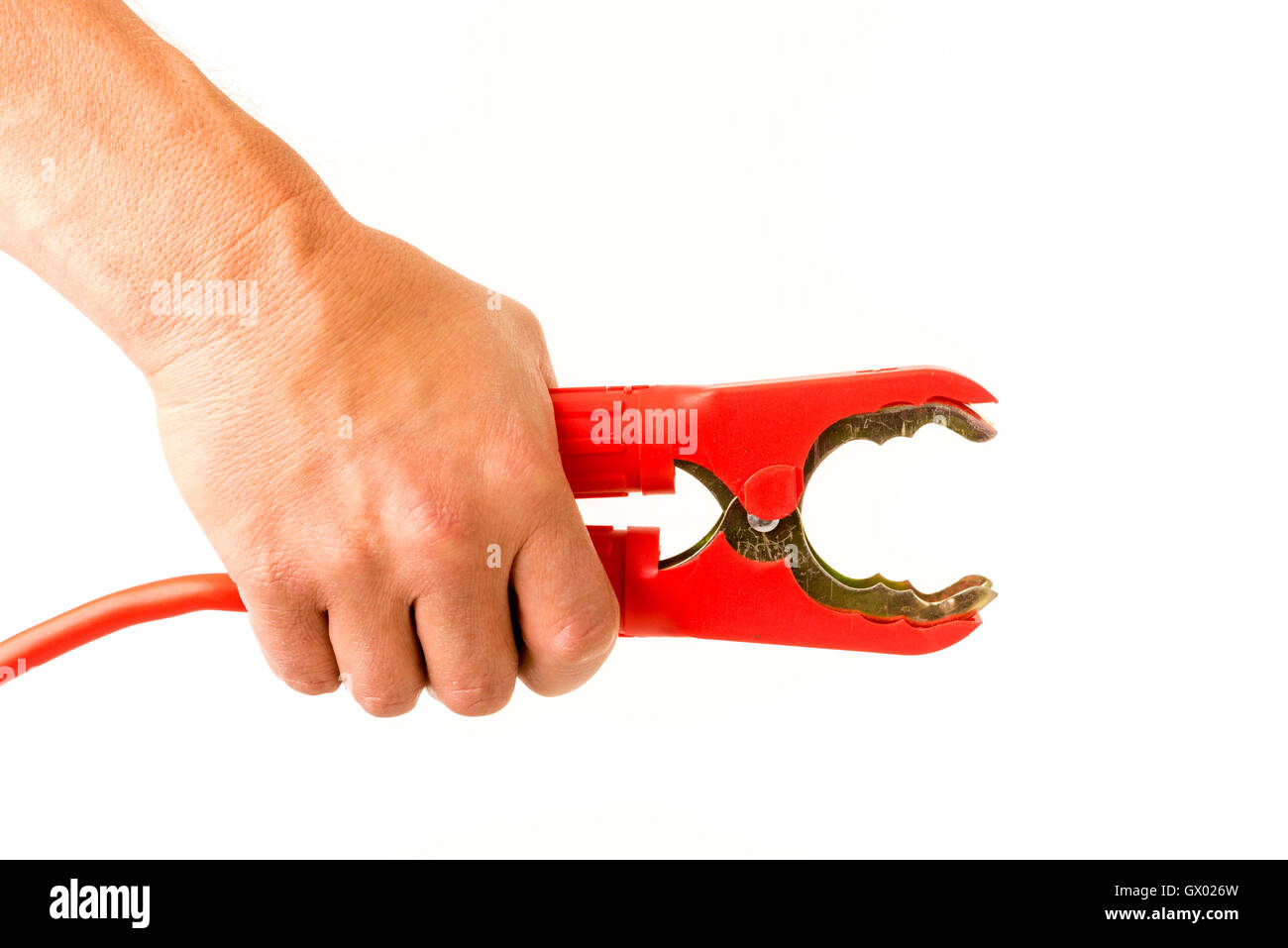 Male hand squeezing car positive red jump lead clamp open Stock Photo