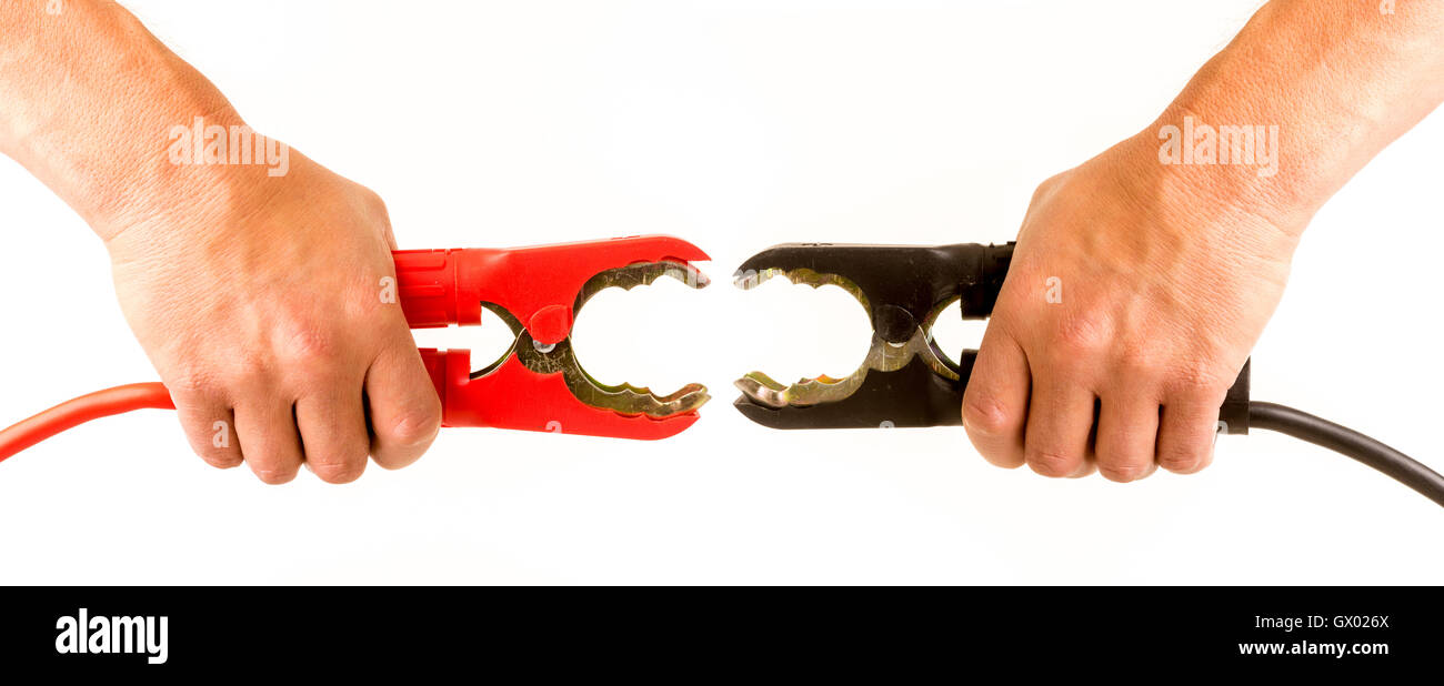 Male hands squeezing car positive red and negative black jump lead