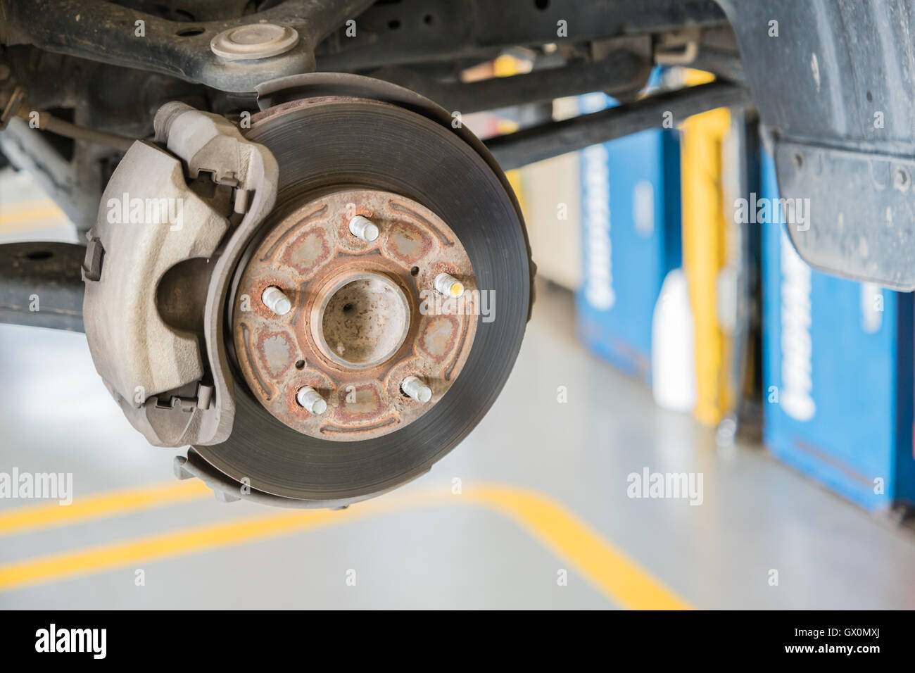 Front disc brake on car in process of new tire replacement Stock Photo