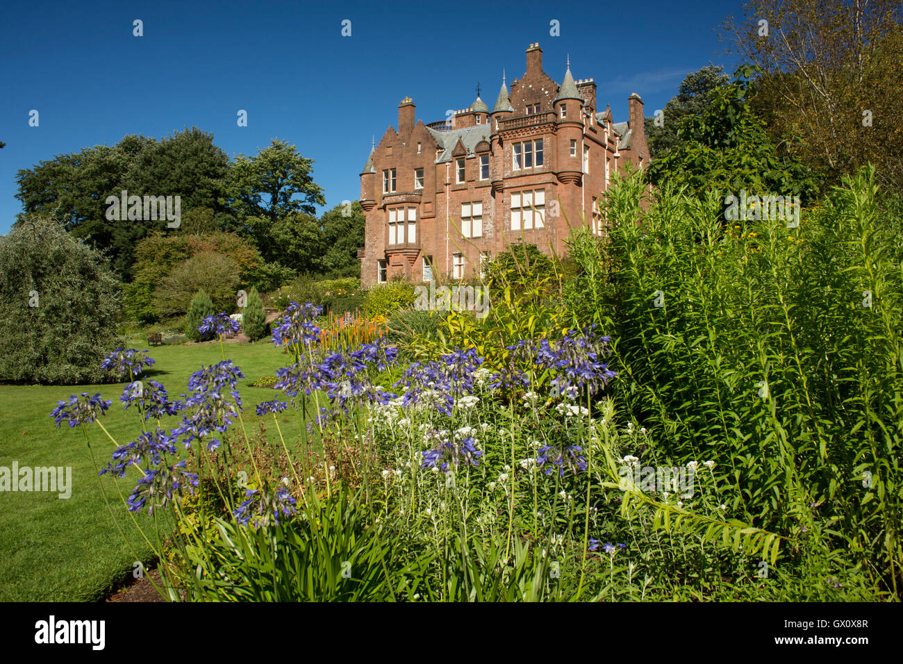 Threave Gardens owned by the National Trust for Scotland. Looking up Threave House a fine Scottish Baronial style house, within  Stock Photo
