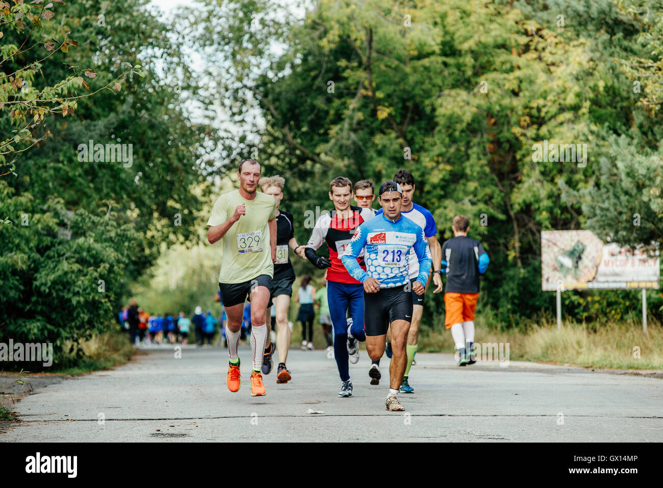 group men of middle age runners running in autumn Park during City marathon Stock Photo