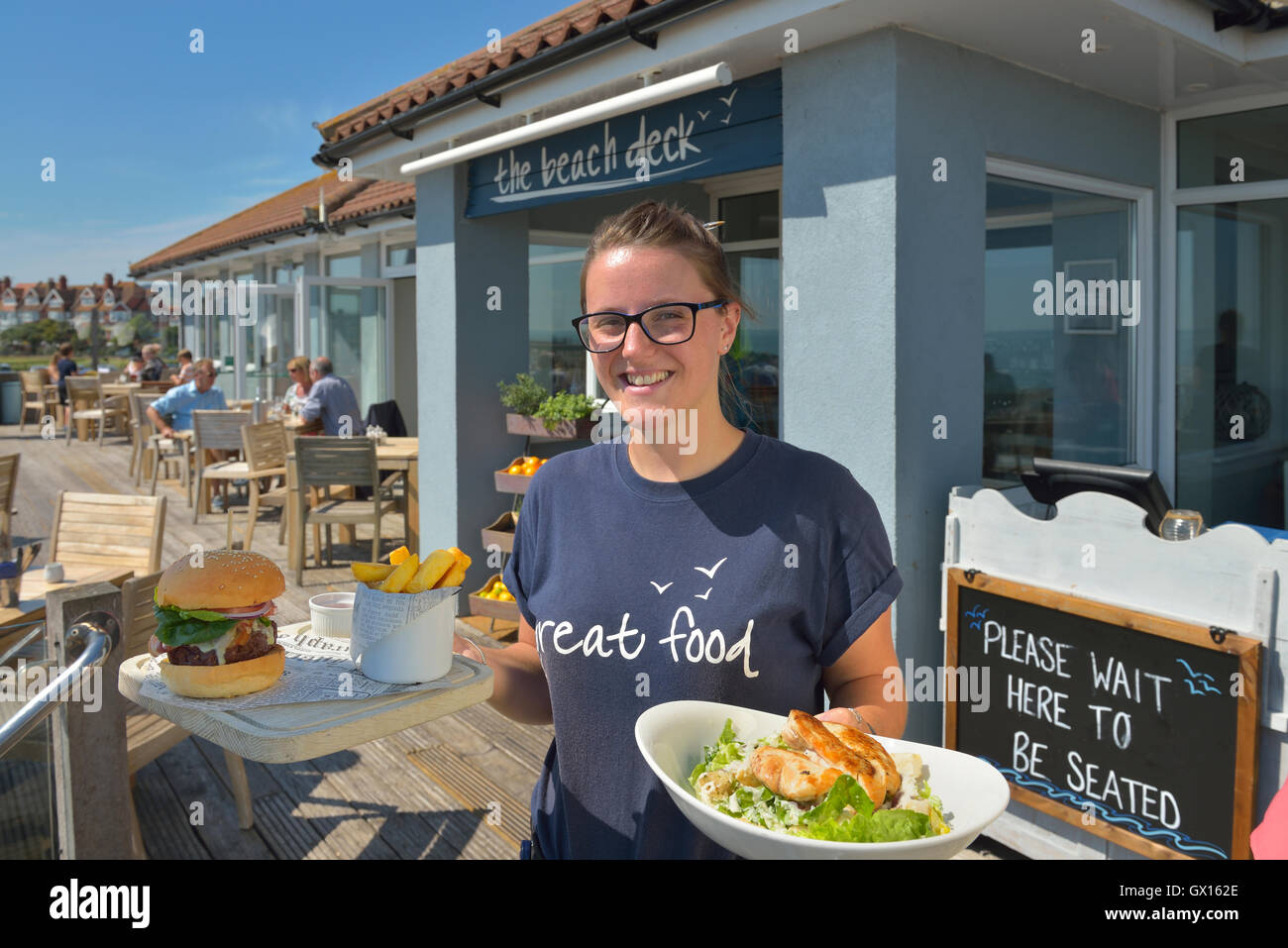 Waitress serving food at The Beach Deck. Eastbourne. Sussex. England