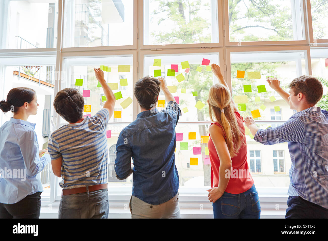 Young students at brainstorming seminar with colorful sticky notes Stock Photo