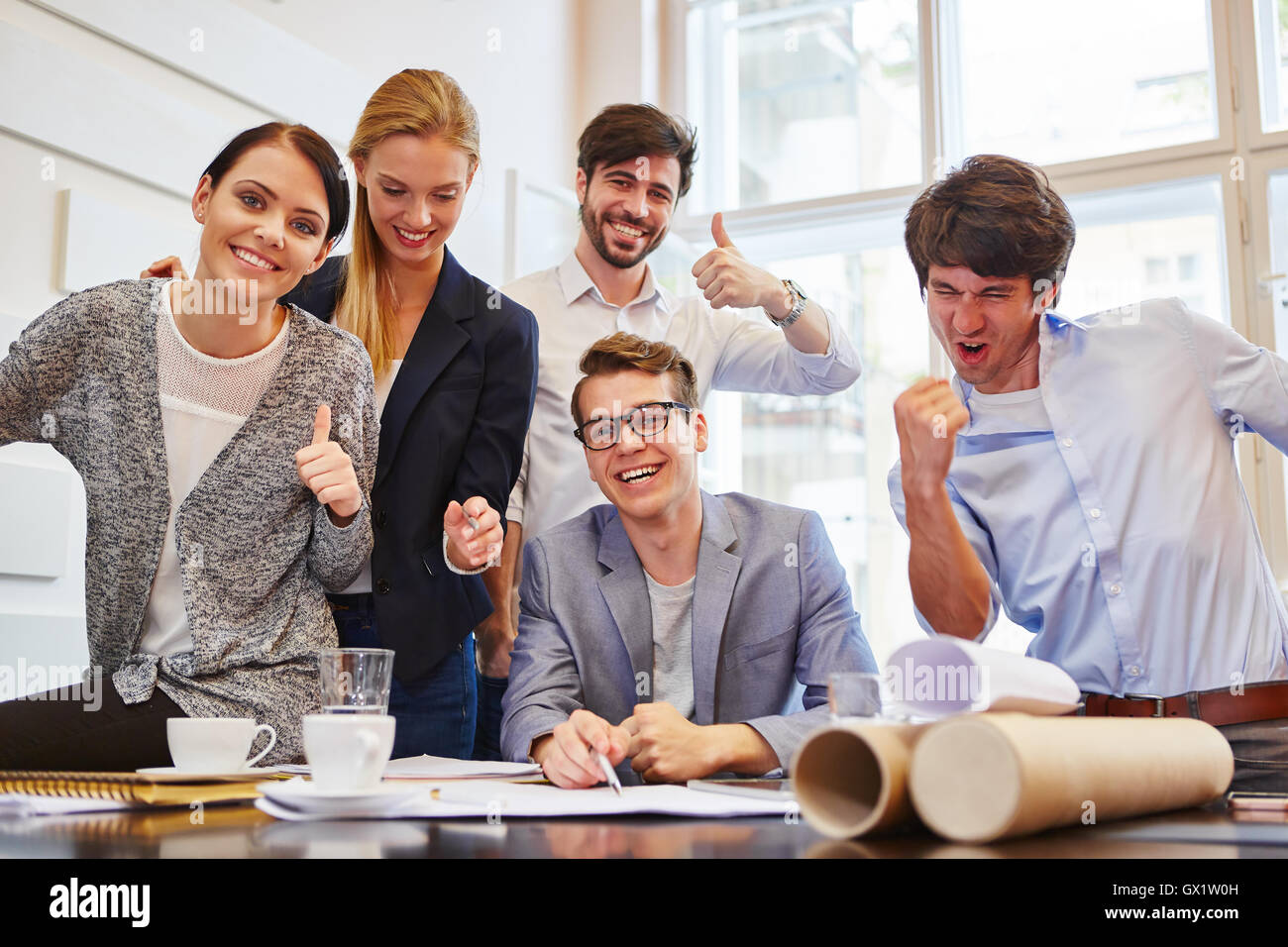 Business team holding thumbs up in succesful start-up company Stock Photo