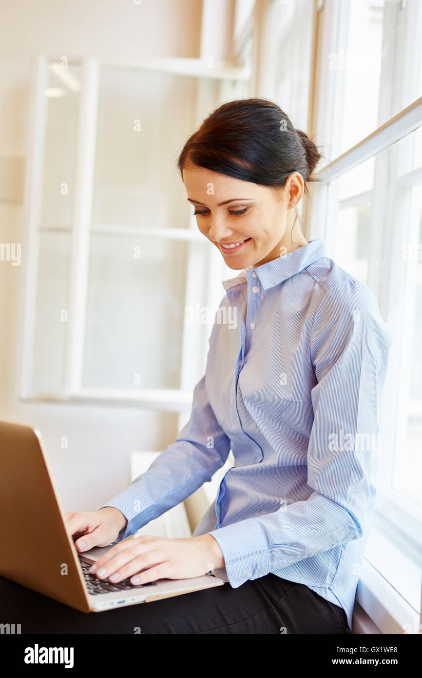 Young woman writing on laptop as a student Stock Photo - Alamy