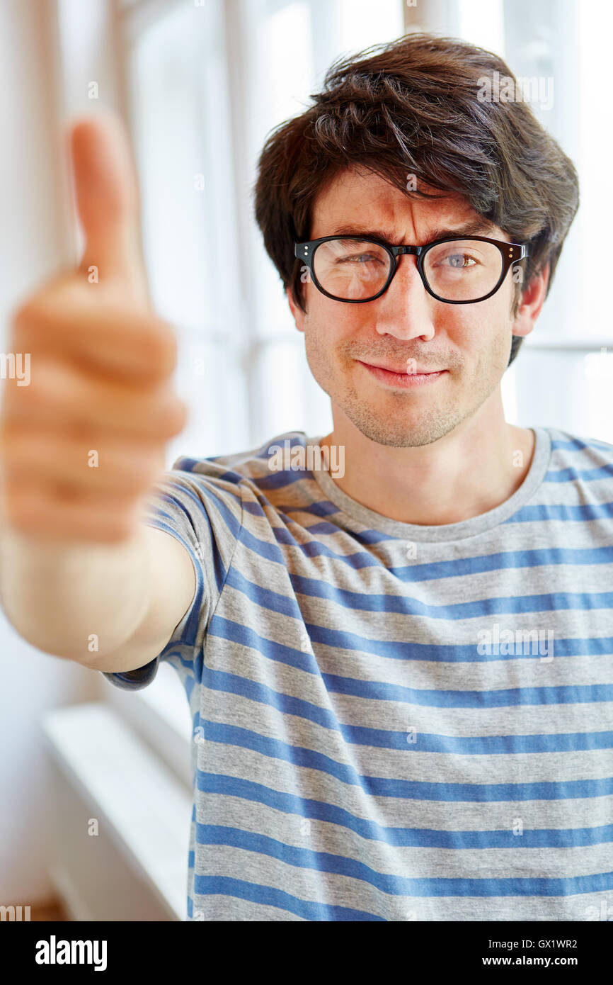 Young man holding humbs up as a sign of consent Stock Photo