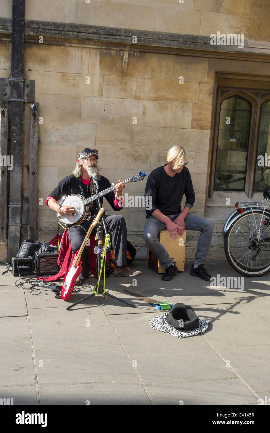 Busker playing banjo with associate in Christs Lane Cambridge City Cambridgeshire England 2016 Stock Photo