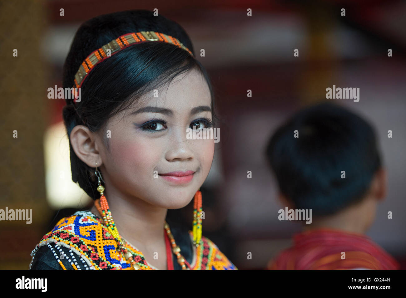 Sweet smile of unidentified portrait of young Torajan pose for camera with traditional costume at a funeral ceremony during the Stock Photo