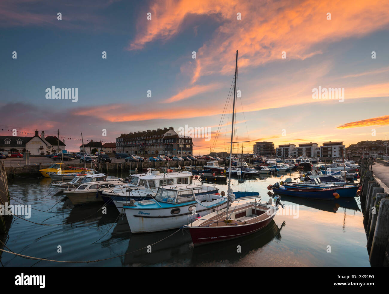 West Bay, Dorset, UK - 14th September 2016. UK Weather. A glorious sunset illuminating the clouds above West Bay Harbour in Dorset, UK. West Bay is one of the locations for the hit ITV series Broadchurch. Picture: Graham Hunt/Alamy Live News Stock Photo