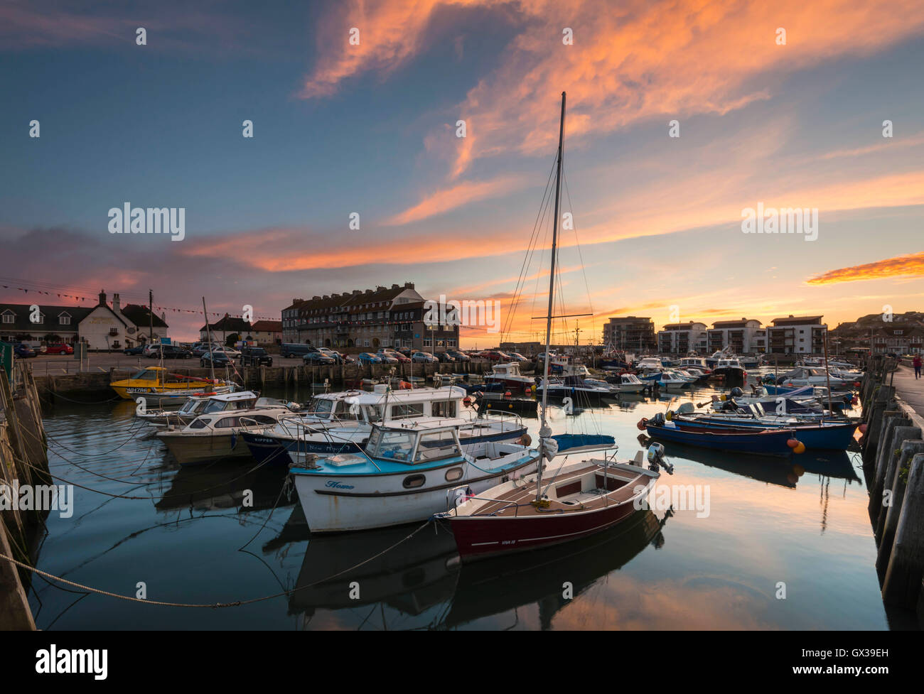 West Bay, Dorset, UK - 14th September 2016. UK Weather.  A glorious sunset illuminating the clouds above West Bay Harbour in Dorset, UK.  West Bay is one of the locations for the hit ITV series Broadchurch.  Picture: Graham Hunt/Alamy Live News Stock Photo