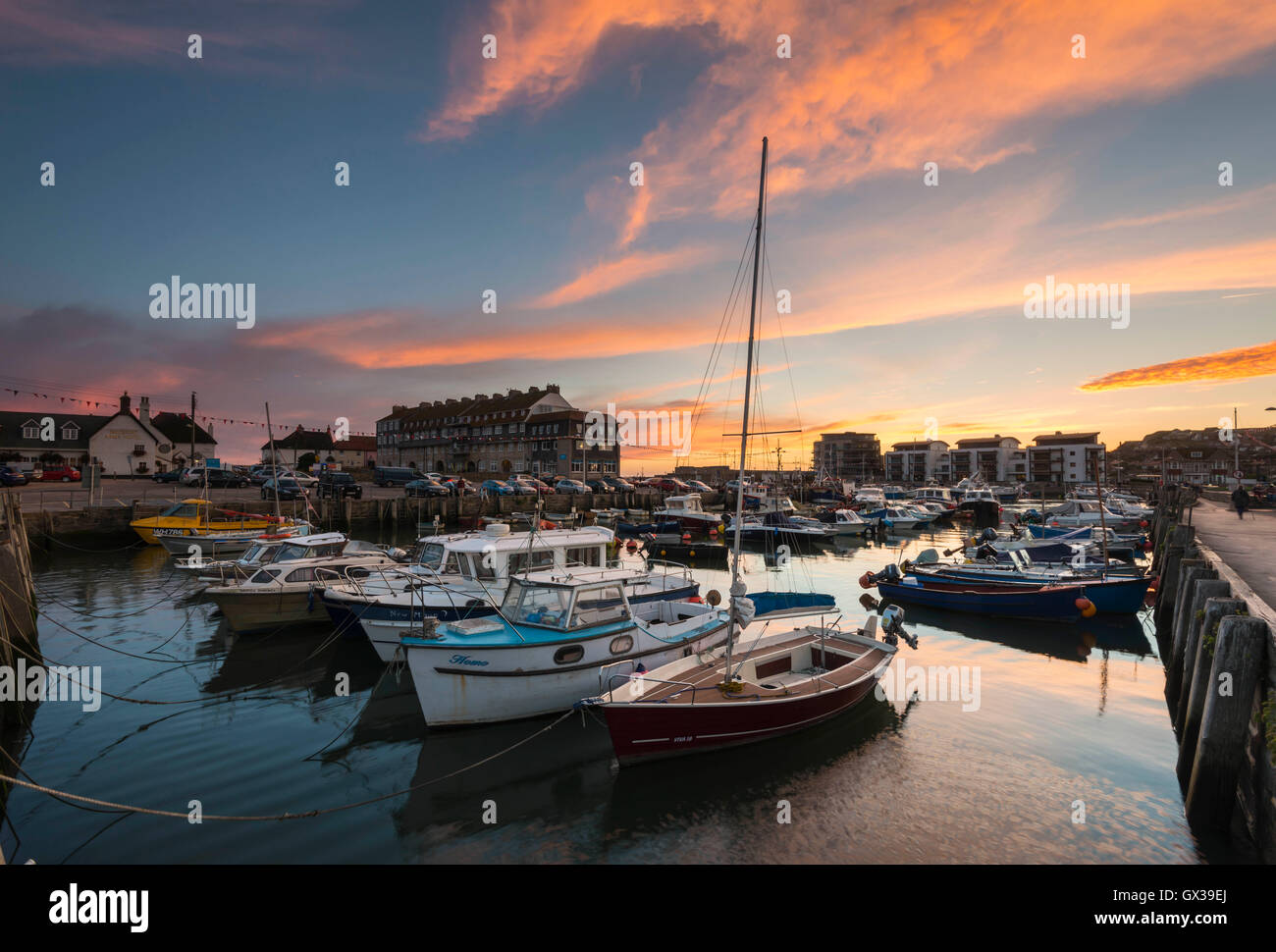 West Bay, Dorset, UK - 14th September 2016. UK Weather.  A glorious sunset illuminating the clouds above West Bay Harbour in Dorset, UK.  West Bay is one of the locations for the hit ITV series Broadchurch.  Picture: Graham Hunt/Alamy Live News Stock Photo
