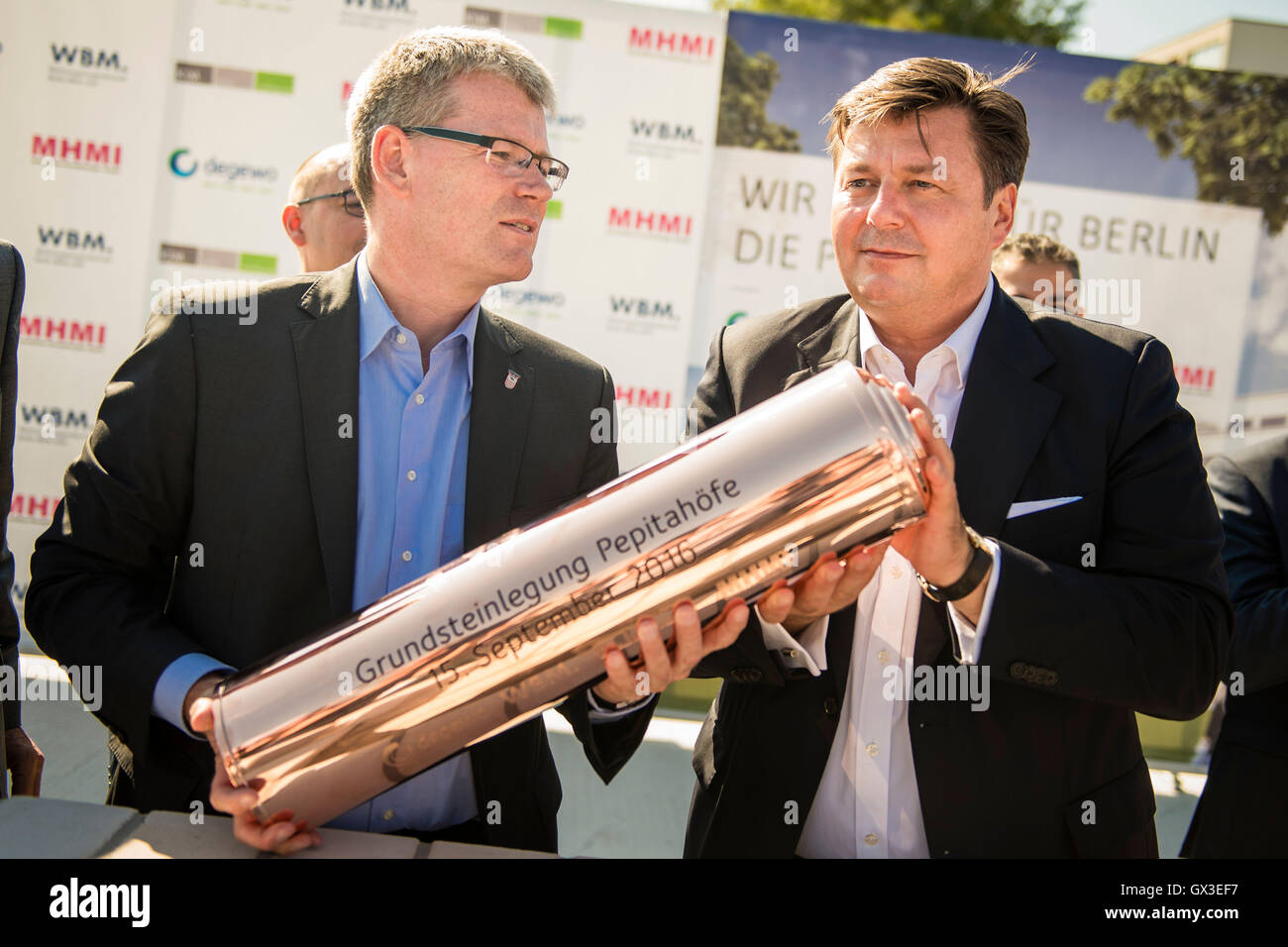 The borough mayor of Berlin-Spandau, Helmut Kleebank (SPD, l-r), and the senator for city development and environment, Andreas Geisel (SPD), fill a time capsule with building plans and a daily newspaper, at the laying of the first stone for the residential construction project "Pepitahoefe" in Berlin, Germany, 15 September 2016. The Pepitahoefe are a new construction project by degewo and the Wohnungsbaugesellschaft Berlin-Mitte GmbH. A total of 1024 apartments are to be built on the 58,700 square metre site by the end of 2018. PHOTO: GREGOR FISCHER/DPA Stock Photo