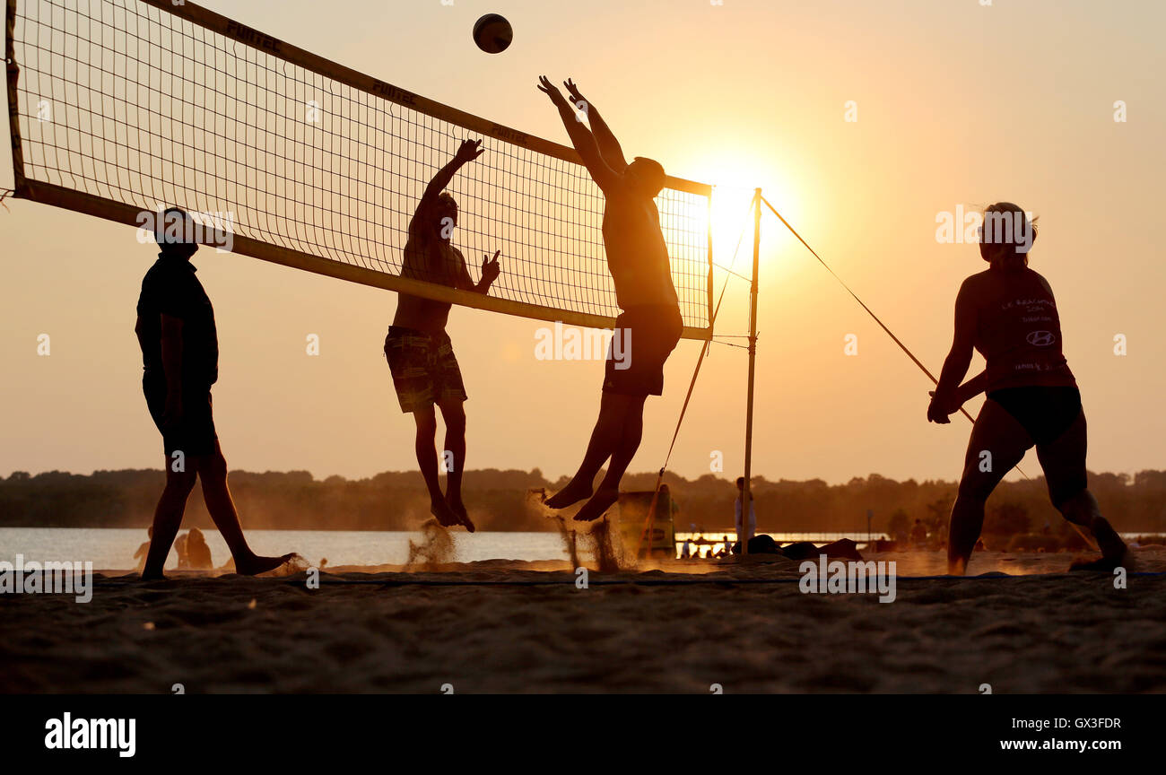 Leipzig, Germany. 14th Sep, 2016. Volleyball players pictured in the light of the setting sun at the Cospudener See lake in Leipzig, Germany, 14 September 2016. PHOTO: JAN WOITAS/DPA/Alamy Live News Stock Photo