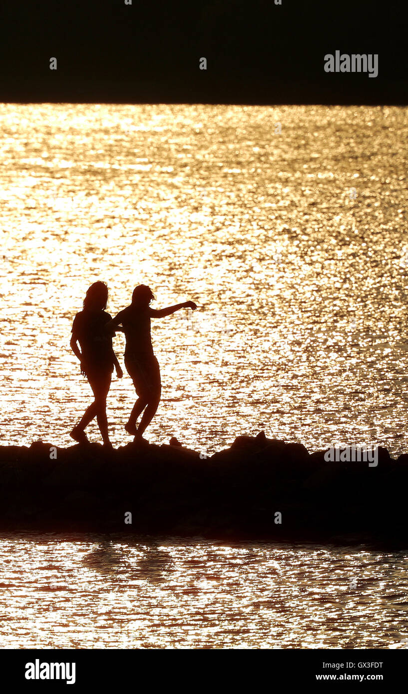 Leipzig, Germany. 14th Sep, 2016. Two people balancing on a jetty in the light of the setting sun at the Cospudener See lake in Leipzig, Germany, 14 September 2016. PHOTO: JAN WOITAS/DPA/Alamy Live News Stock Photo