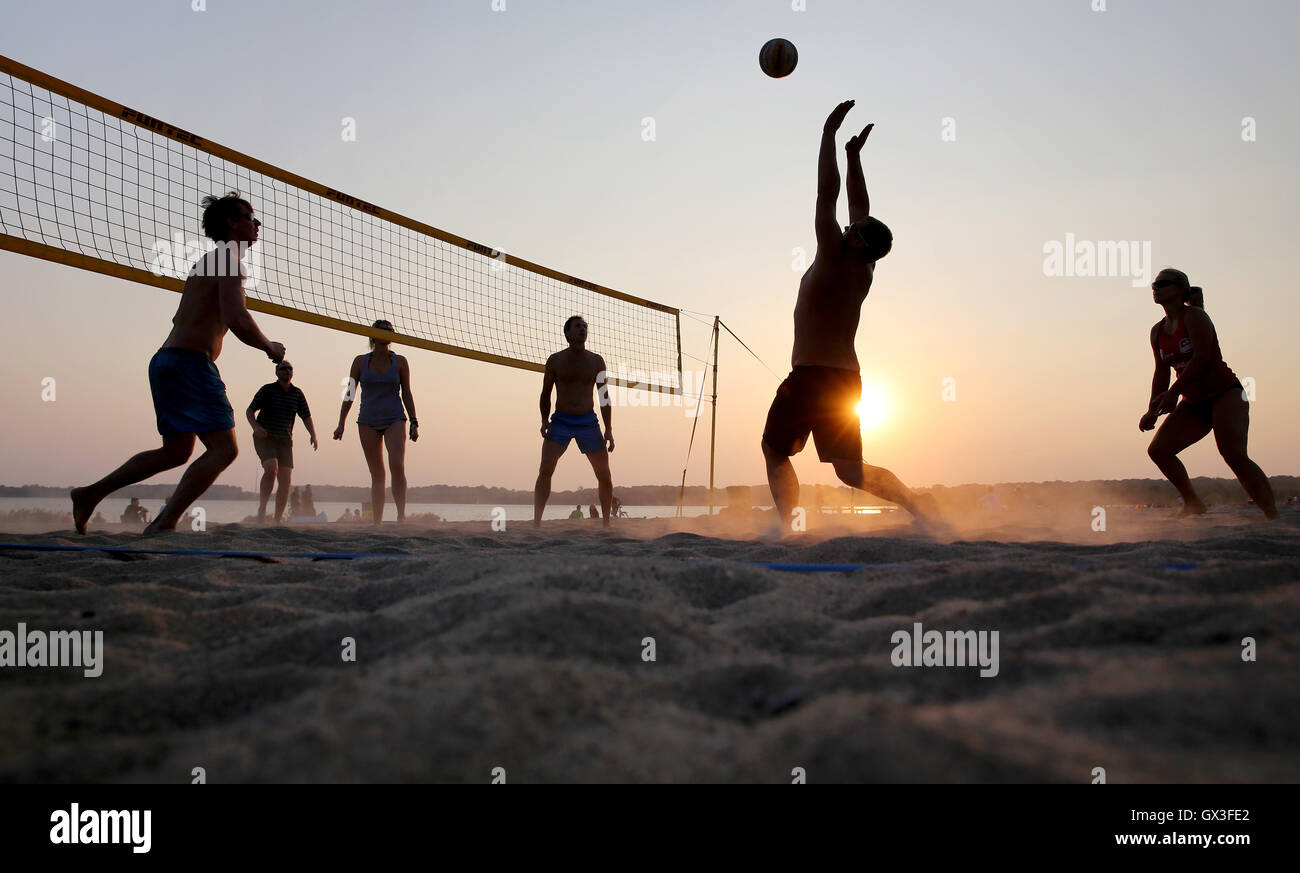 Leipzig, Germany. 14th Sep, 2016. Volleyball players pictured in the light of the setting sun at the Cospudener See lake in Leipzig, Germany, 14 September 2016. PHOTO: JAN WOITAS/DPA/Alamy Live News Stock Photo