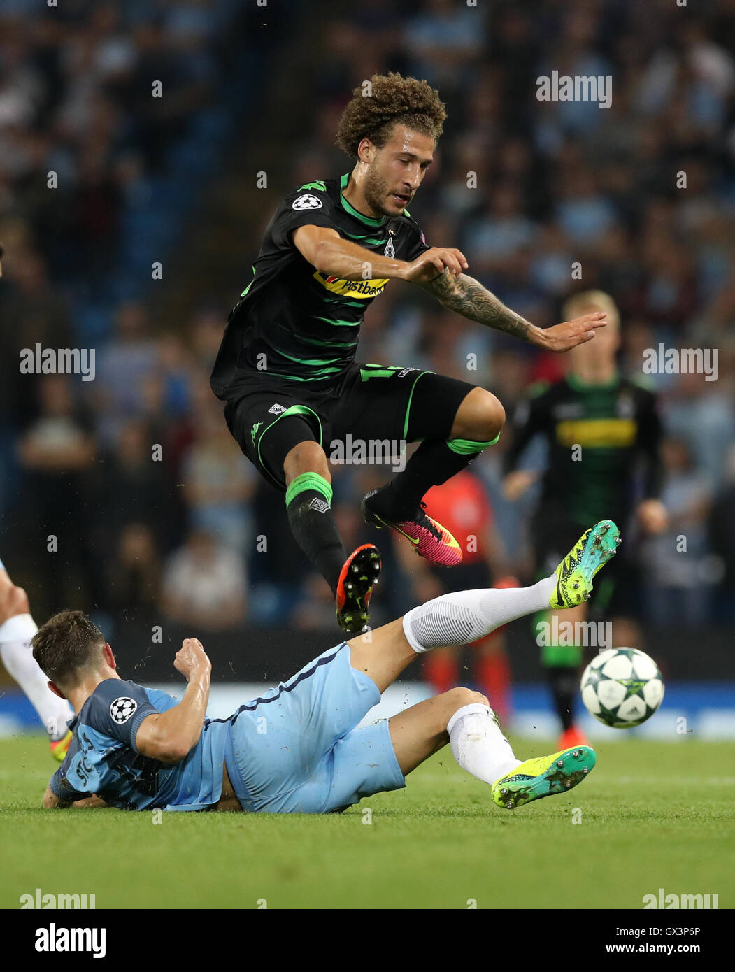 Manchester City's John Stones and Borussia Monchengladbach'a Fabian Johnson battle for the ball during the Champions League match at the Etihad Stadium, Manchester. Stock Photo