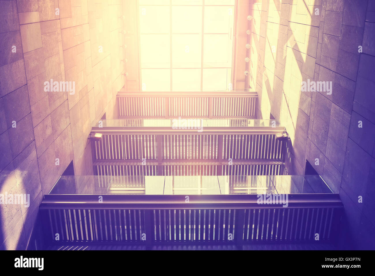 Vintage toned modern building interior with roof window at sunset. Stock Photo